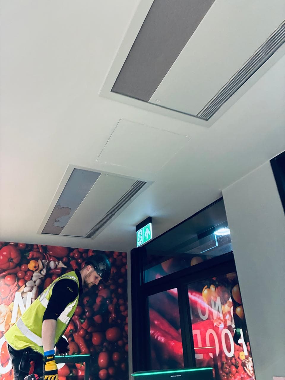 Technician carrying out a ceiling air conditioning installation